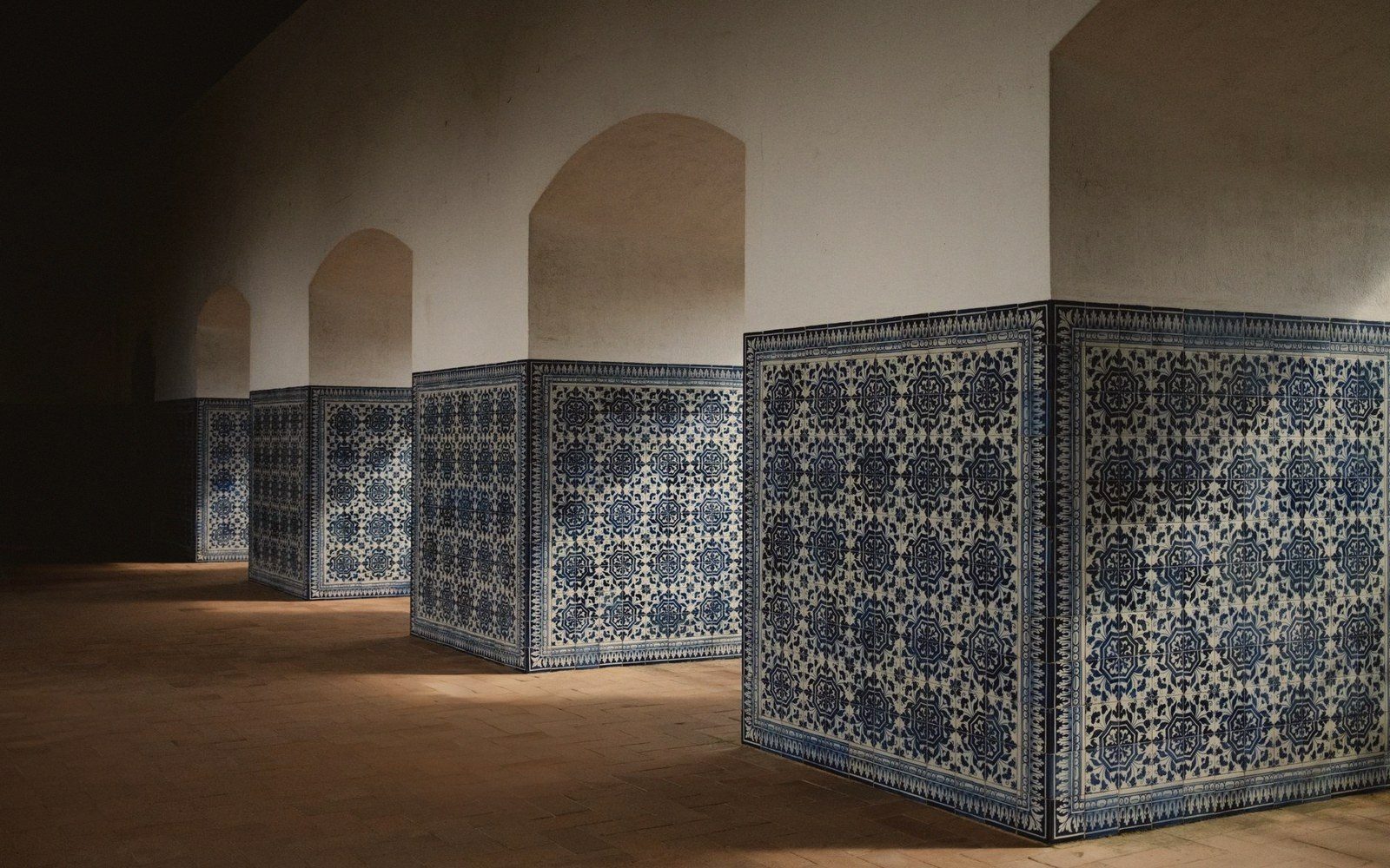 A tiled stairwell, blue-and-white azulejos on both walls, receding upward